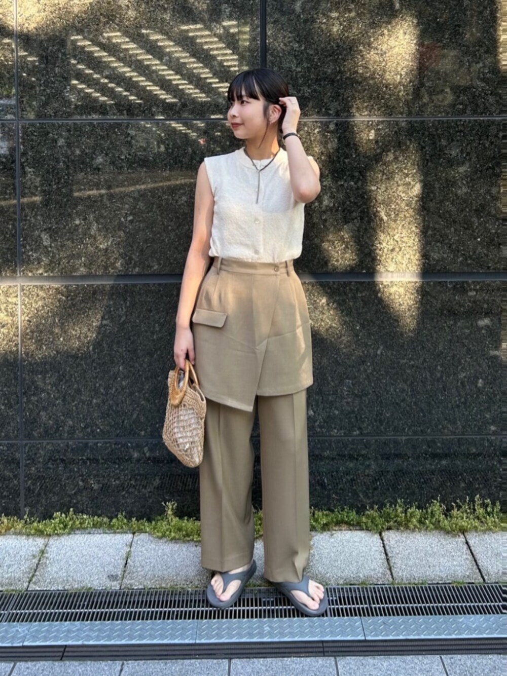 ベージュ系のかごバッグ、ベージュ系のその他パンツ、ホワイト系のベストを着用したレディースの夏コーディネートの1枚目の写真