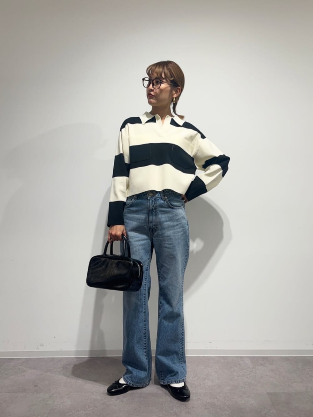 ブルー系のデニムパンツ、ブラック系のニット/セーターを着用したレディースの冬コーディネートの1枚目の写真