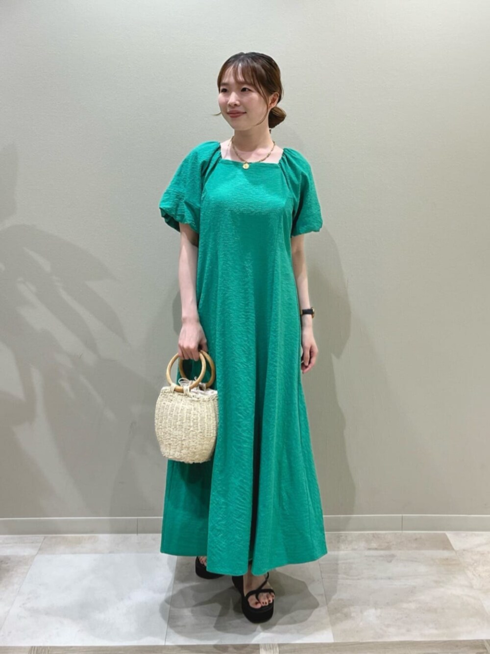 グリーン系のワンピースを着用したレディースの夏コーディネートの1枚目の写真