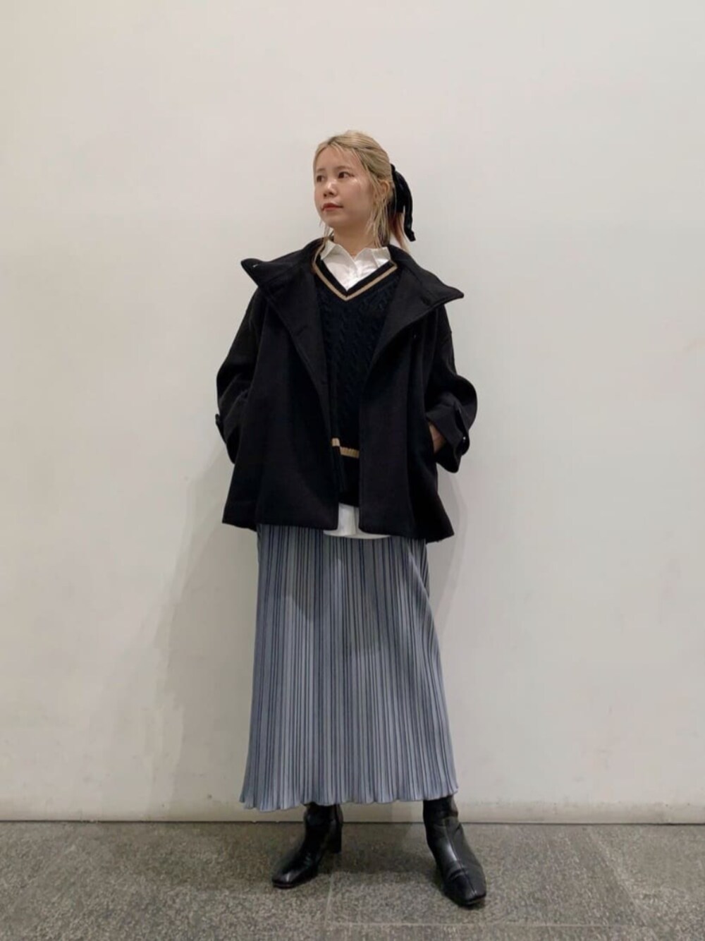 ブラック系のブーツ、ブラック系のステンカラーコート、ホワイト系のシャツ/ブラウスを着用したレディースの冬コーディネートの1枚目の写真