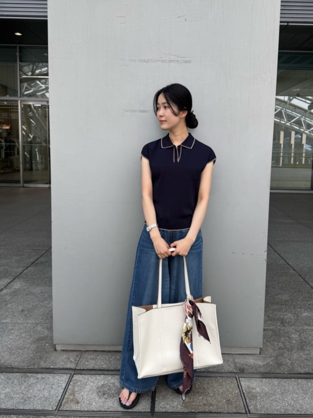 ブルー系のデニムパンツ、ブルー系のポロシャツを着用したレディースの夏コーディネートの1枚目の写真