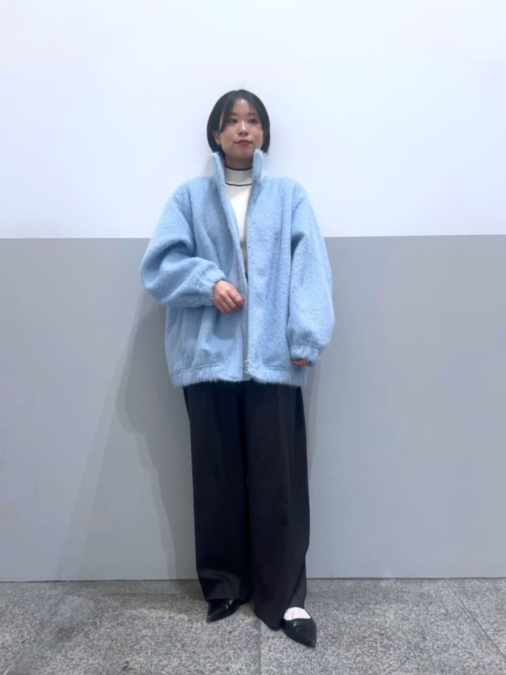 ブルー系のブルゾン、グレー系のその他パンツ、ホワイト系のニット/セーターを着用したレディースの冬コーディネートの1枚目の写真