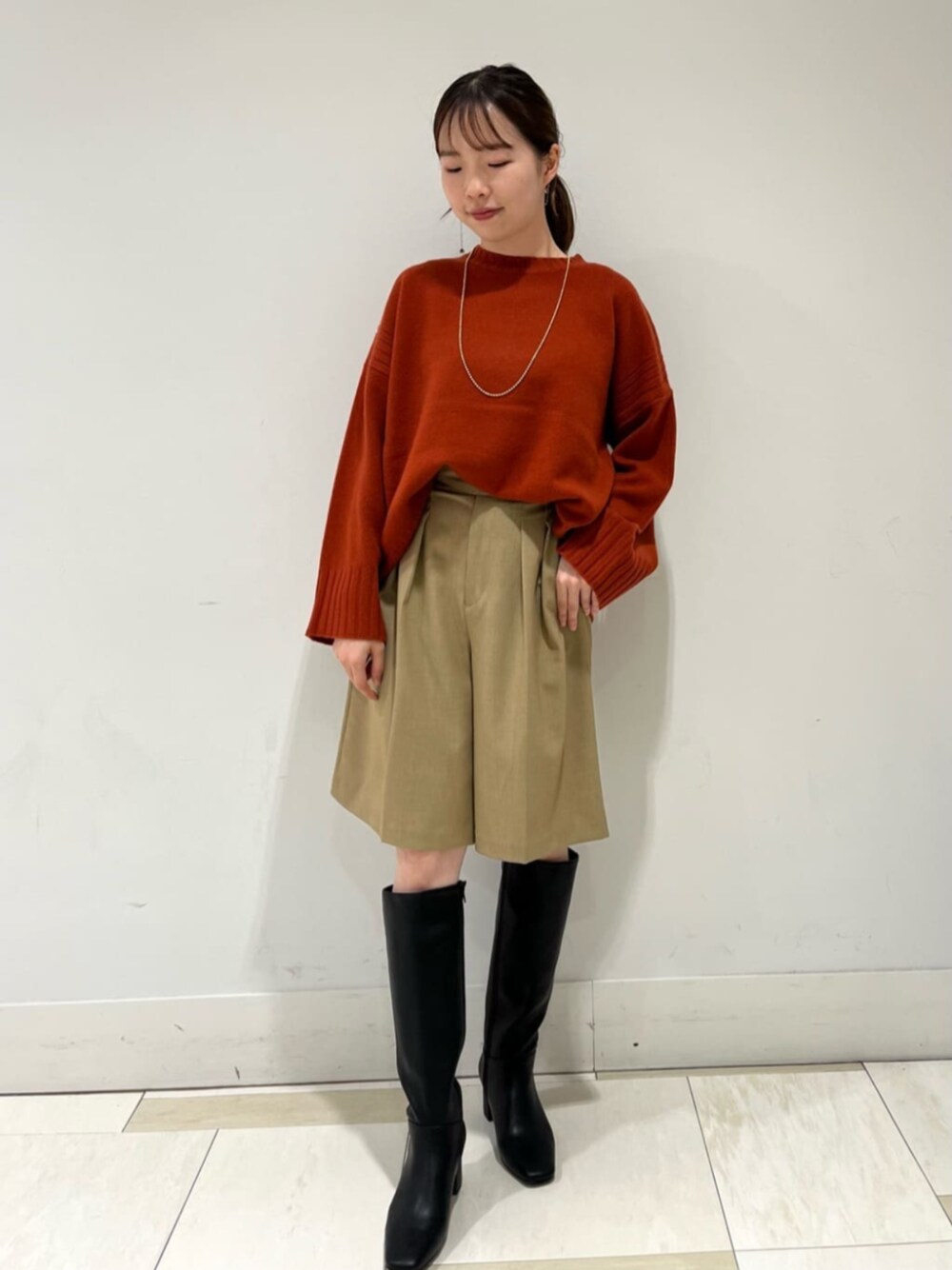 レッド系のニット/セーター、ベージュ系のその他パンツを着用したレディースの秋コーディネートの1枚目の写真