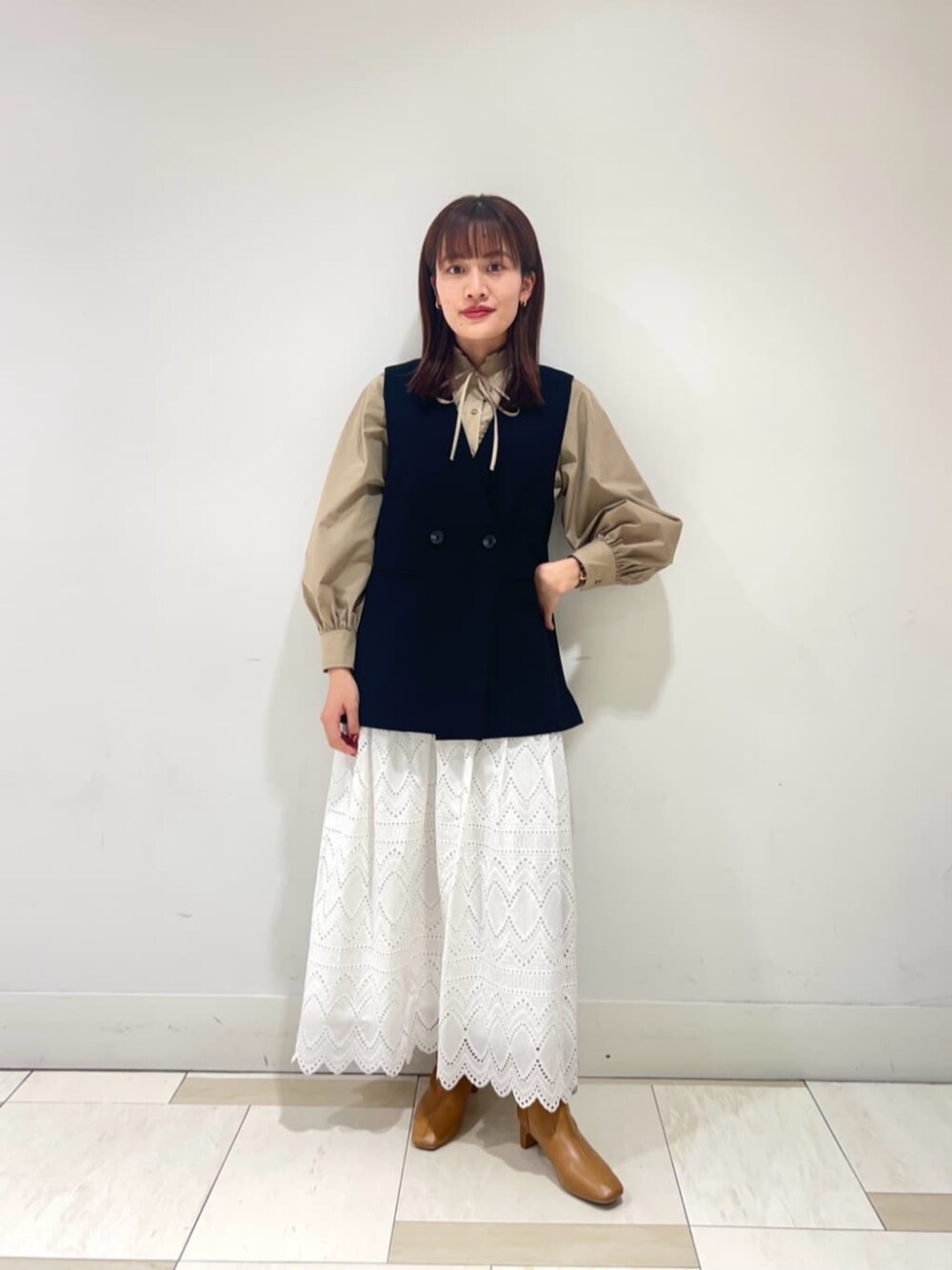 ベージュ系のブーツ、ホワイト系のスカート、ベージュ系のシャツ/ブラウスを着用したレディースの冬コーディネートの1枚目の写真