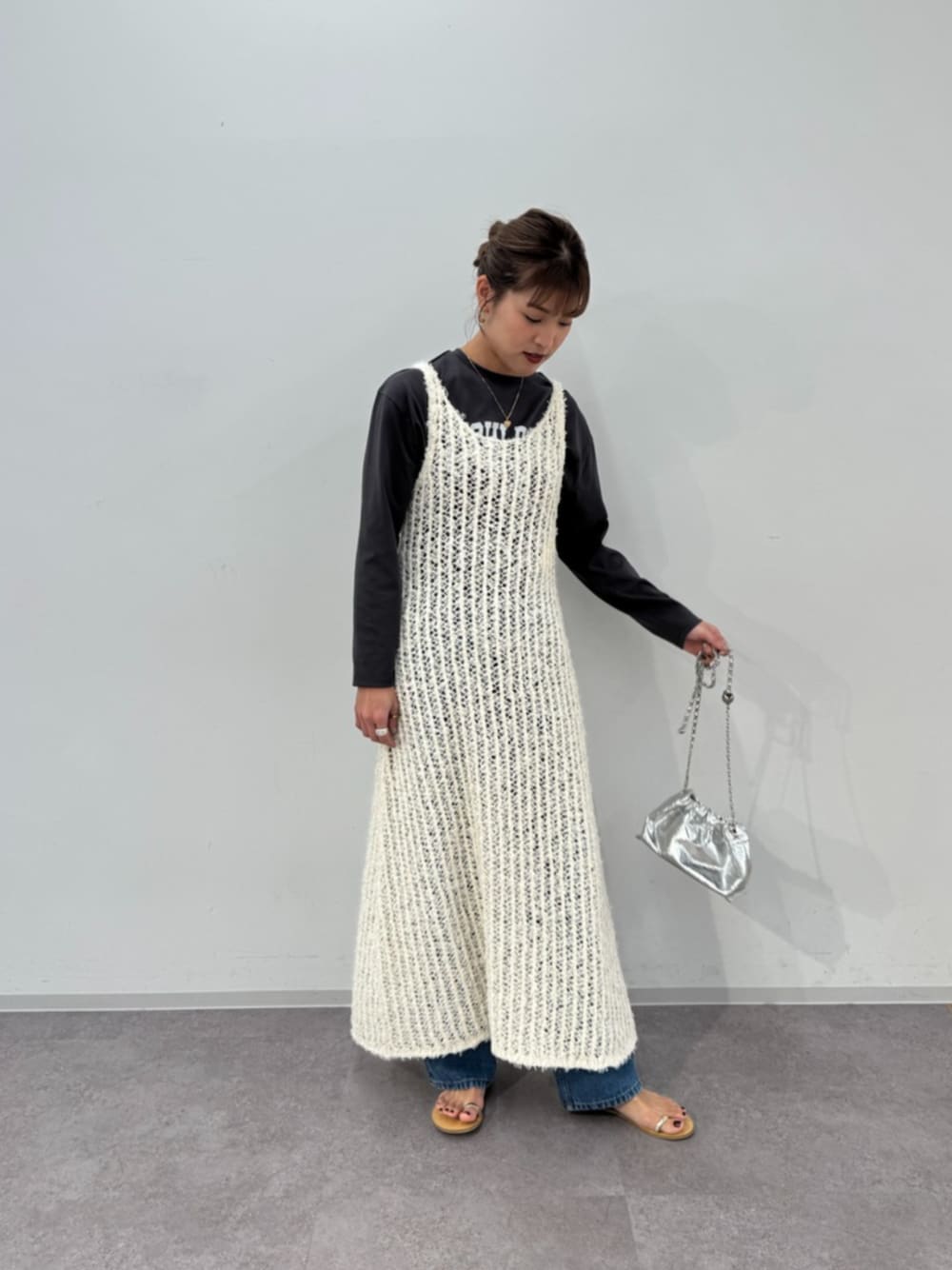 ブルー系のデニムパンツ、ホワイト系のワンピース、グレー系のTシャツ/カットソーを着用したレディースの冬コーディネートの1枚目の写真