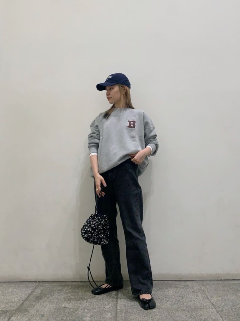 ブラック系のデニムパンツ、ブラック系のショルダーバッグを着用したレディースの春コーディネートの1枚目の写真