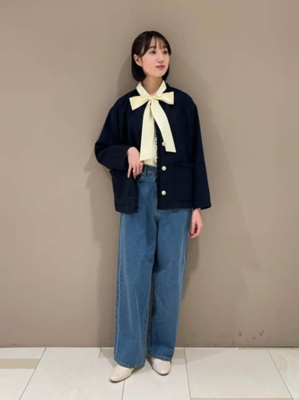 イエロー系のシャツ/ブラウス、ブルー系のノーカラージャケット、ブルー系のデニムパンツを着用したレディースの冬コーディネートの1枚目の写真