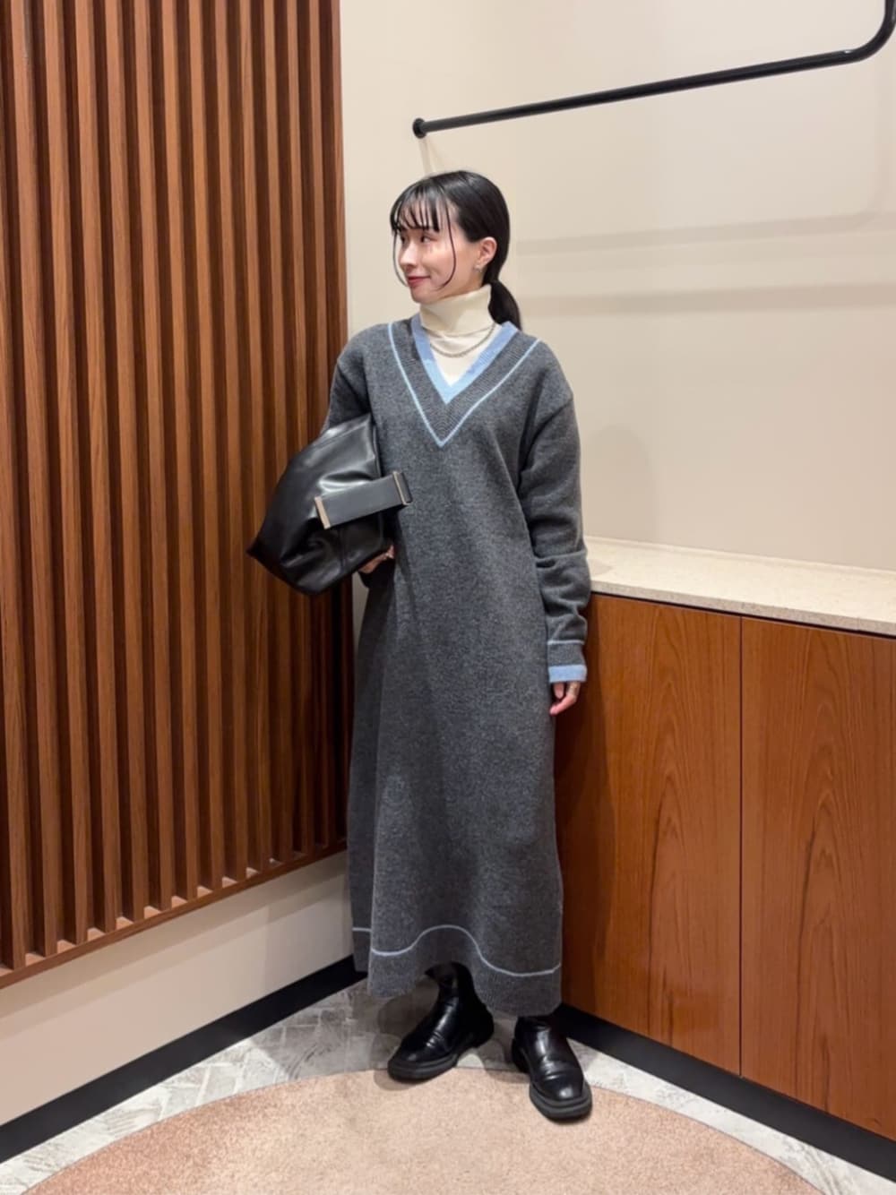 グレー系のワンピース、ホワイト系のニット/セーターを着用したレディースの冬コーディネートの1枚目の写真