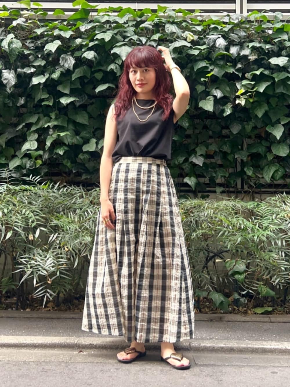 ベージュ系のスカート、ブラック系のタンクトップを着用したレディースの夏コーディネートの1枚目の写真