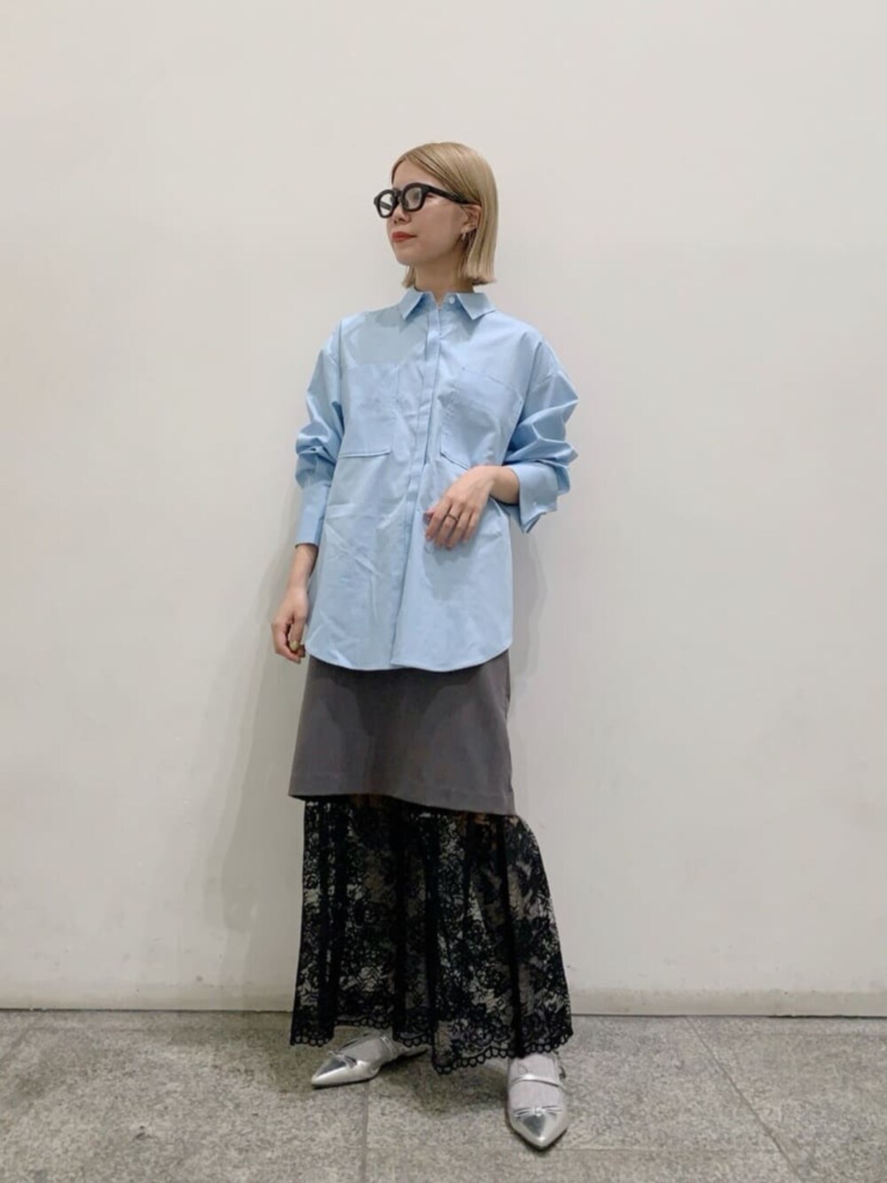 ブルー系のシャツ/ブラウス、グレー系のスカート、シルバー系のパンプスを着用したレディースの秋コーディネートの1枚目の写真