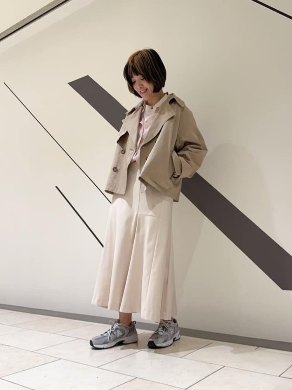 ベージュ系のトレンチコート、ピンク系のシャツ/ブラウス、ホワイト系のスカートを着用したレディースの春コーディネートの1枚目の写真