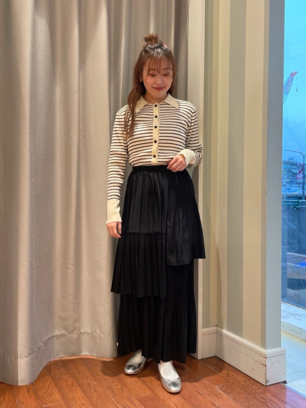 ブラック系のスカート、ホワイト系のカーディガン/ボレロを着用したレディースの春コーディネートの1枚目の写真