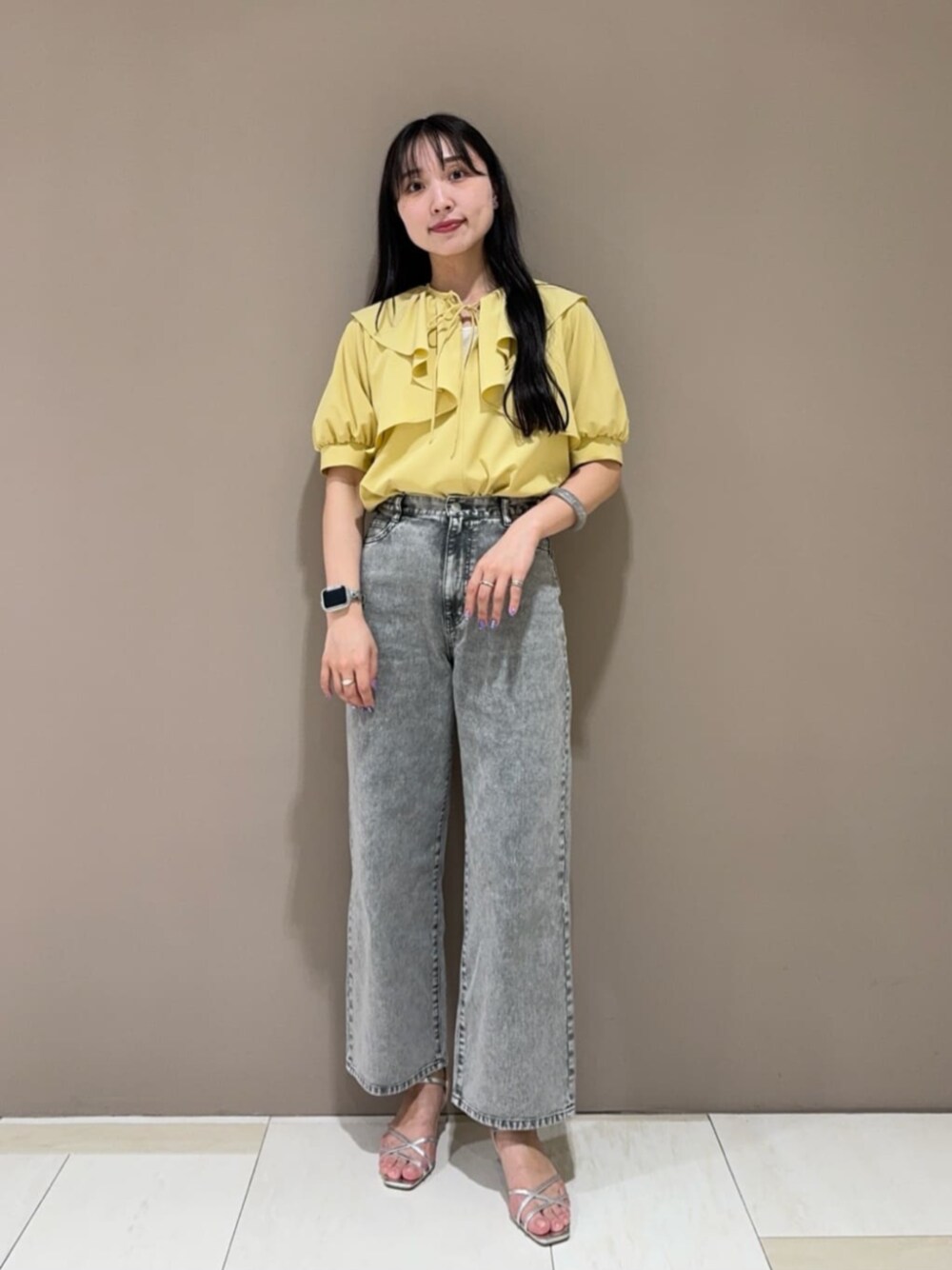 シルバー系のサンダル、グレー系のデニムパンツ、イエロー系のシャツ/ブラウスを着用したレディースの春コーディネートの1枚目の写真