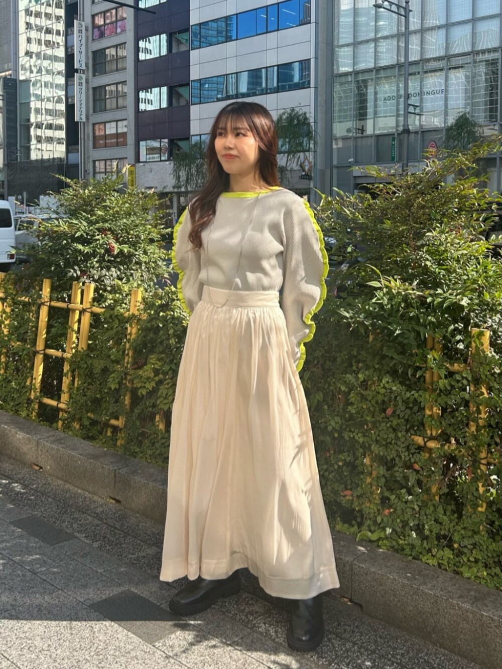 ブラック系のブーツ、グレー系のニット/セーター、ベージュ系のスカートを着用したレディースの冬コーディネートの1枚目の写真