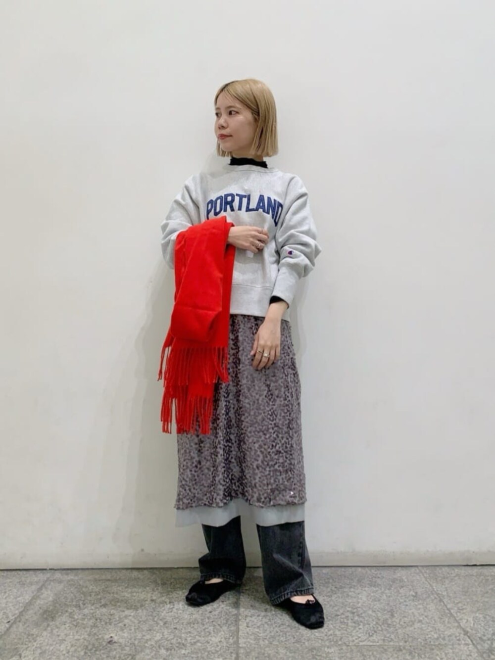 ブラック系のデニムパンツ、ブラック系のTシャツ/カットソー、グレー系のスカートを着用したレディースの秋コーディネートの1枚目の写真