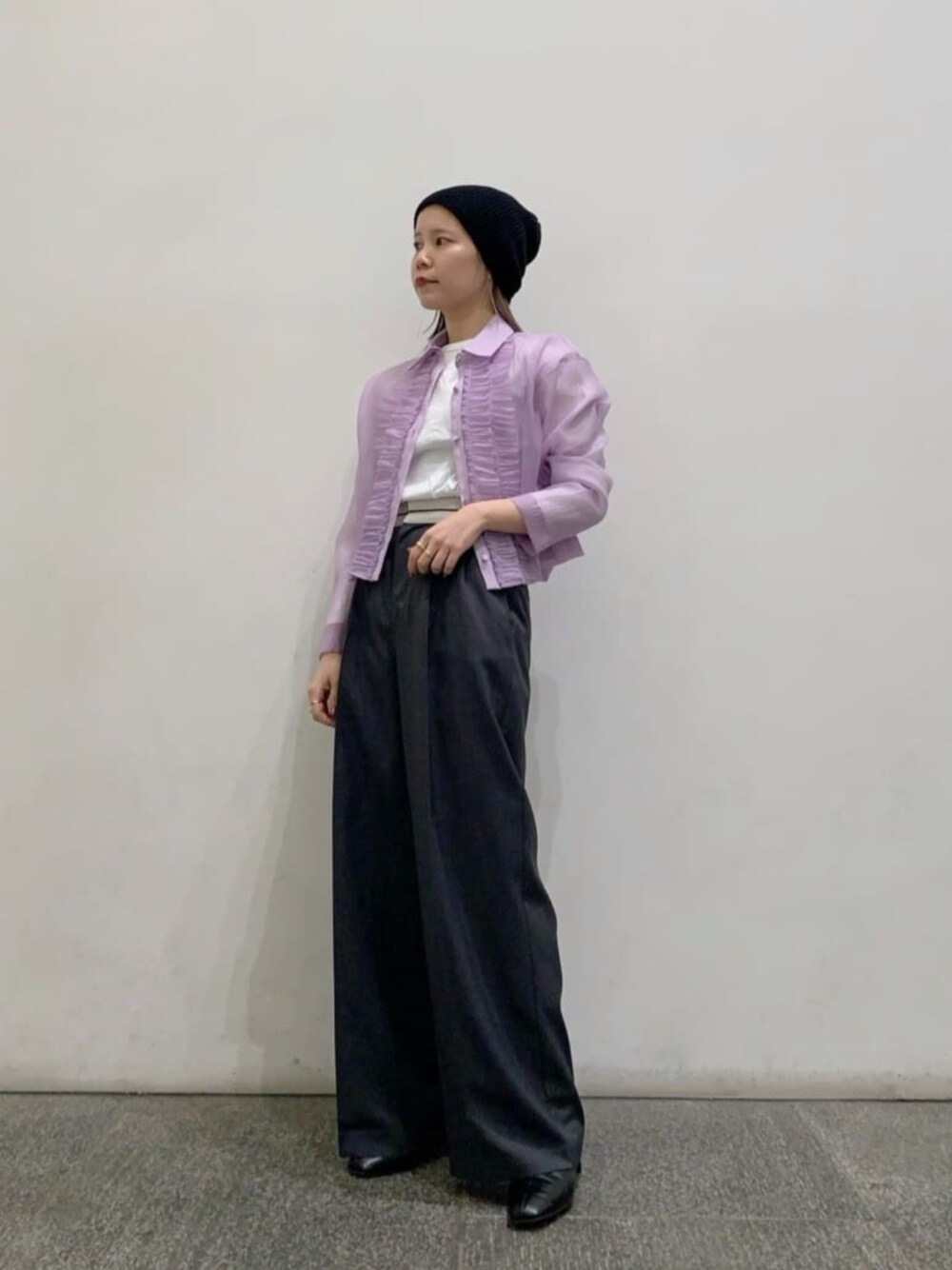 ブラック系のブーツ、ホワイト系のTシャツ/カットソー、グレー系のスラックスを着用したレディースの冬コーディネートの1枚目の写真