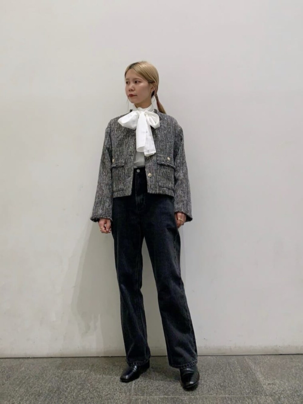 ブラック系のブーツ、ブラック系のデニムパンツ、ホワイト系のTシャツ/カットソーを着用したレディースの冬コーディネートの1枚目の写真