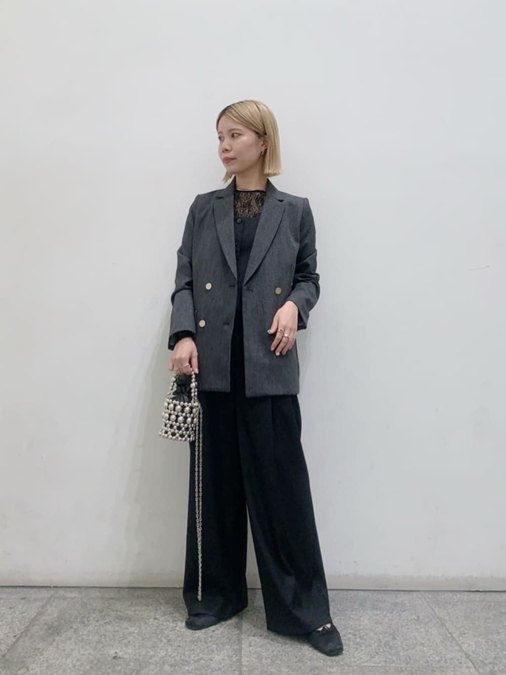 グレー系のテーラードジャケット、ブラック系のセットアップ、ブラック系のTシャツ/カットソーを着用したレディースの秋コーディネートの1枚目の写真