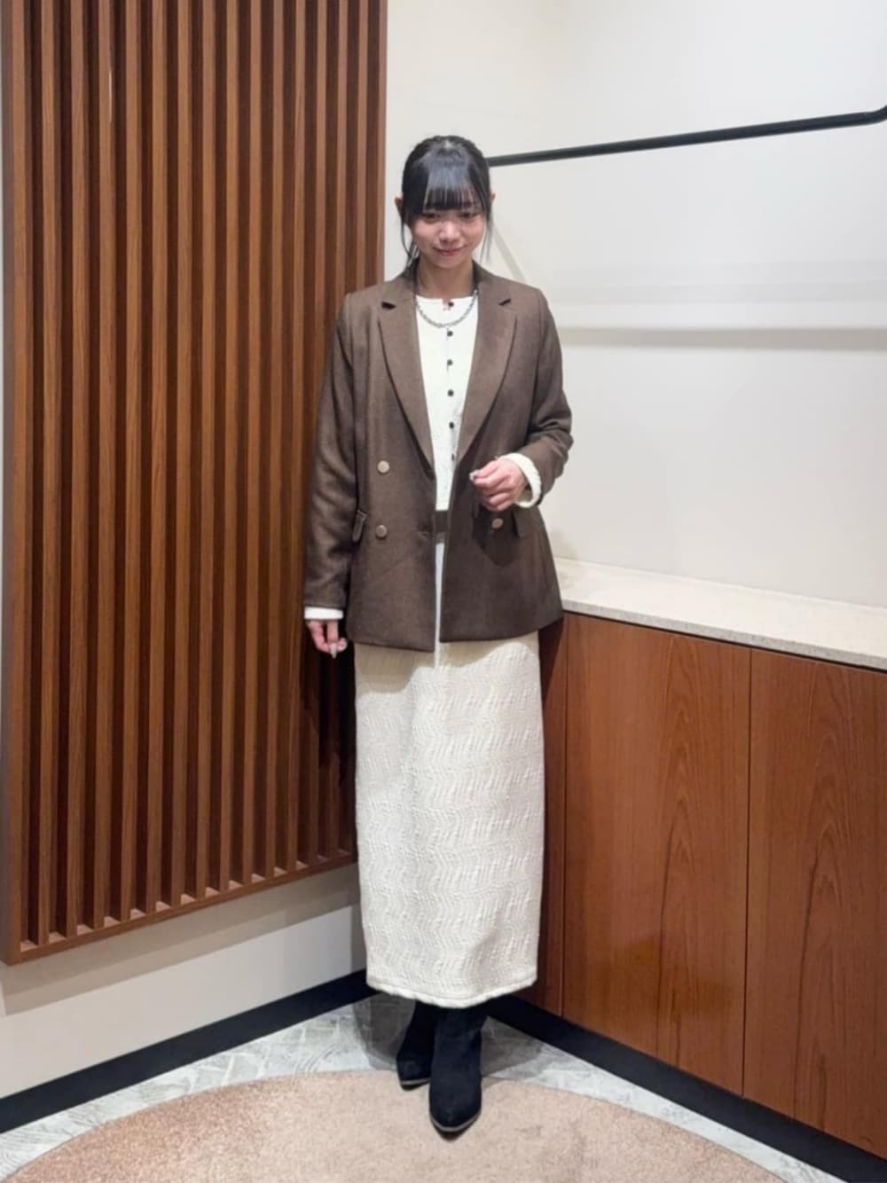 ホワイト系のセットアップ、ブラウン系のテーラードジャケットを着用したレディースの冬コーディネートの1枚目の写真