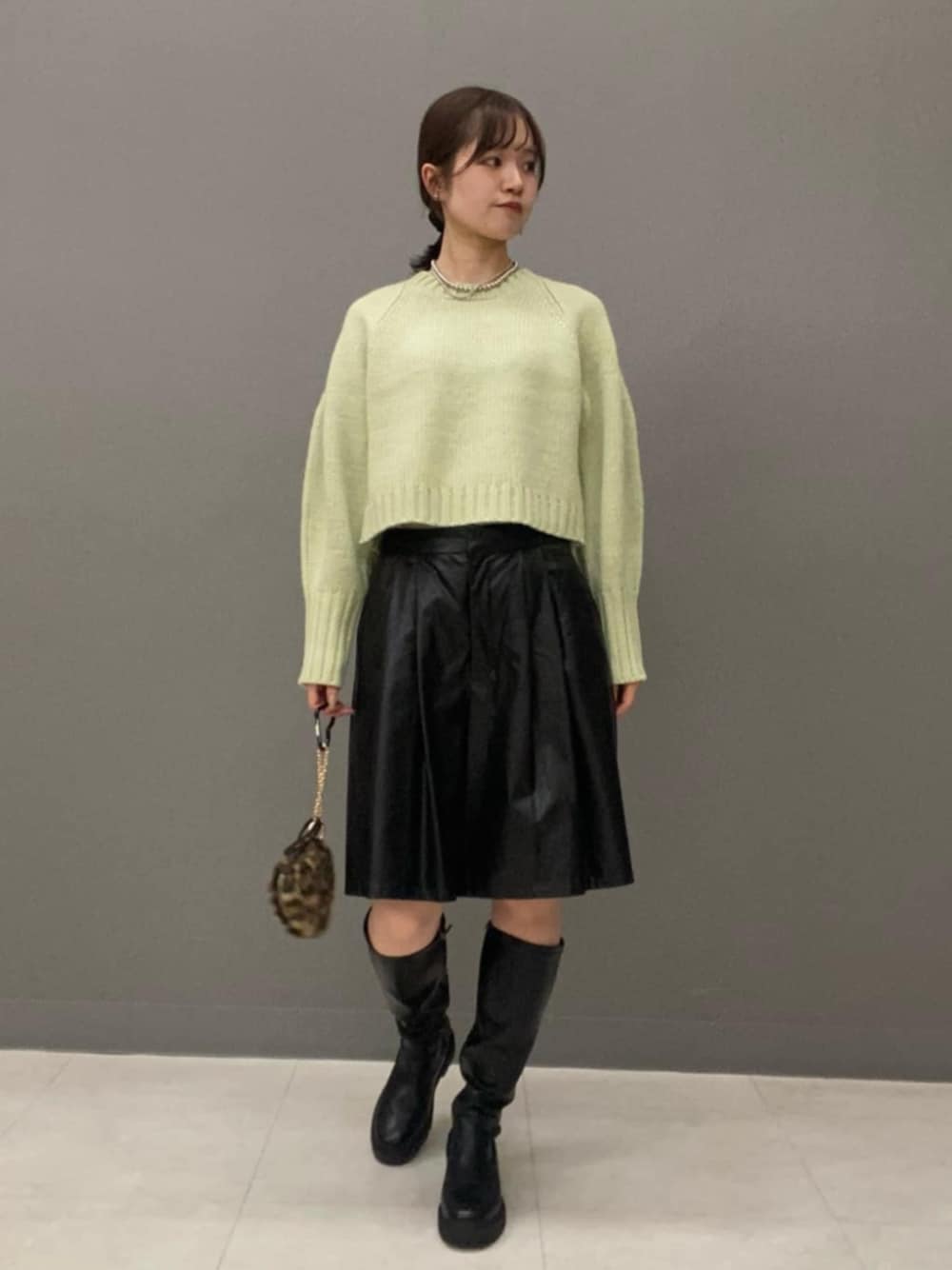 グリーン系のニット/セーター、ブラック系のその他パンツを着用したレディースの秋コーディネートの1枚目の写真