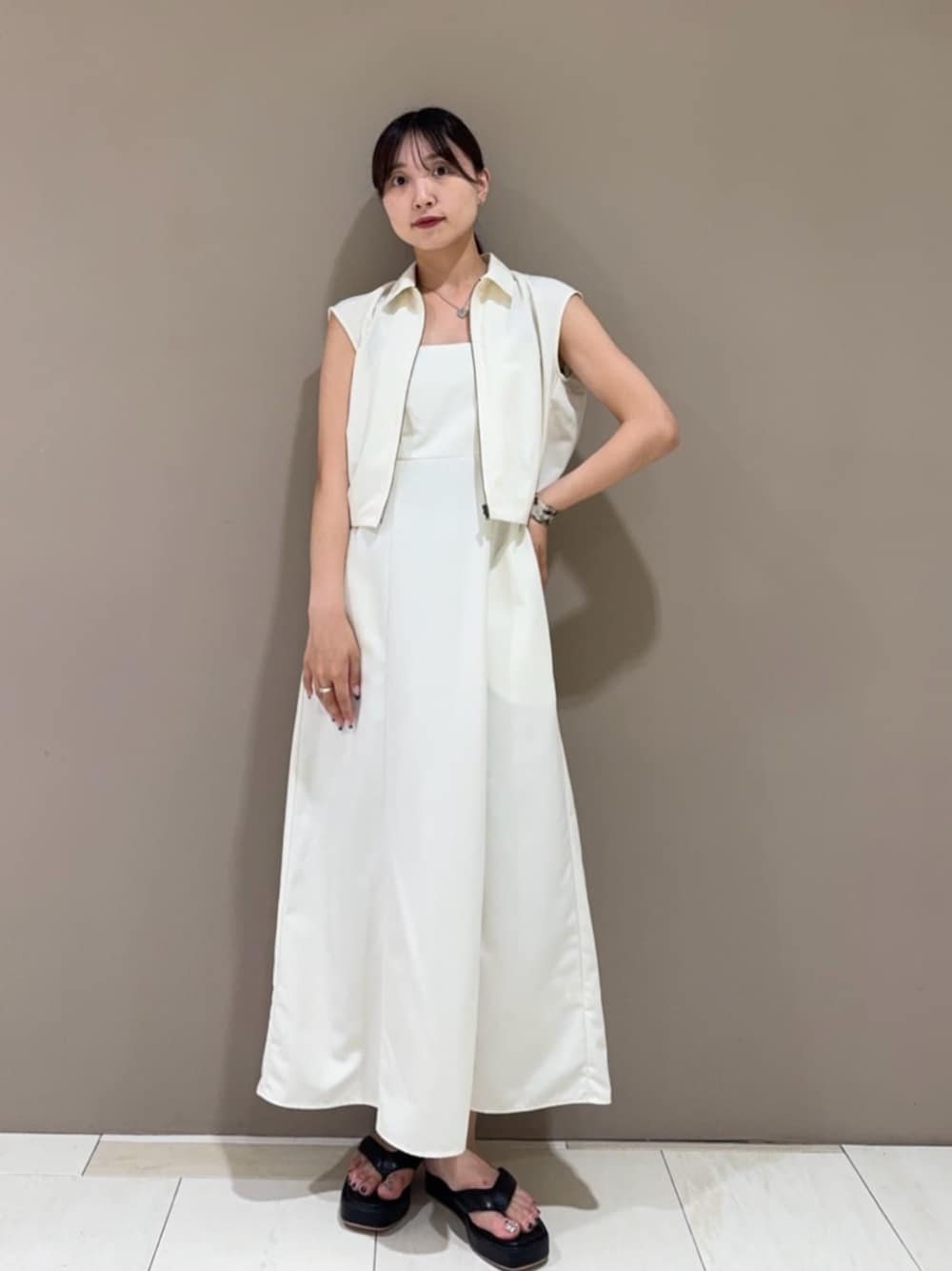 ブラック系のサンダル、ホワイト系のワンピース、ベージュ系のバングル/リストバンドを着用したレディースの夏コーディネートの1枚目の写真