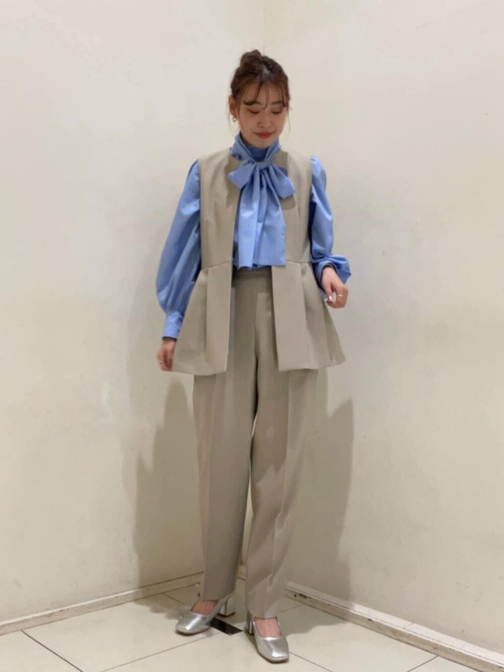 シルバー系のパンプス、ブルー系のTシャツ/カットソー、ベージュ系のセットアップを着用したレディースの冬コーディネートの1枚目の写真