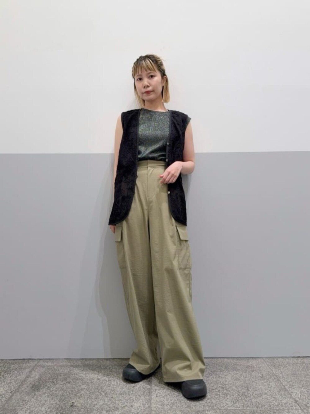 グリーン系のカーゴパンツ、ブラック系のベスト、ブラック系のTシャツ/カットソーを着用したレディースの夏コーディネートの1枚目の写真
