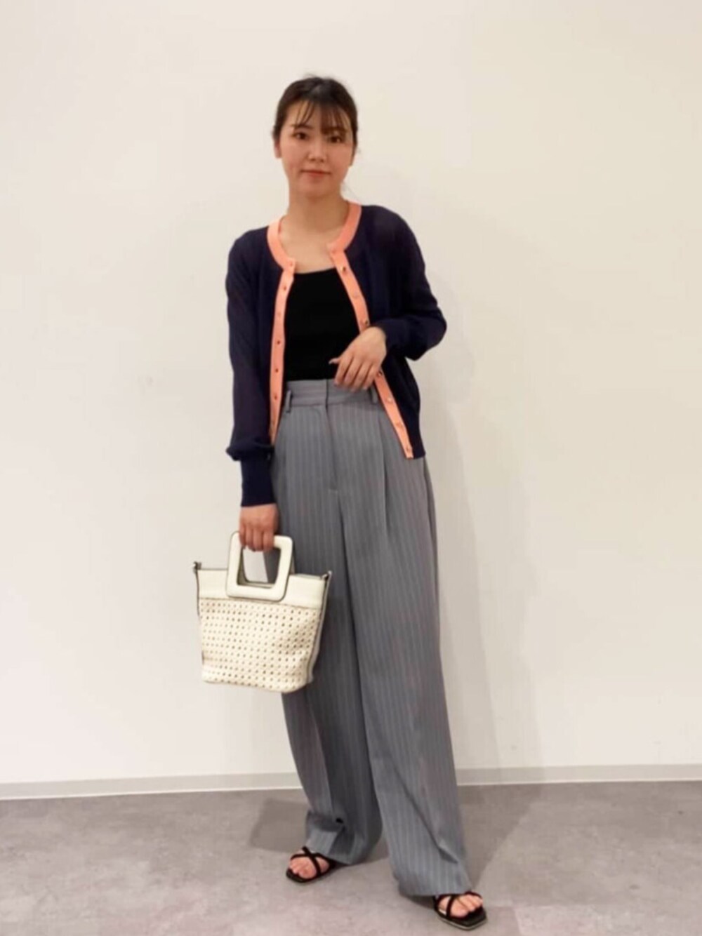 シルバー系のサンダル、ホワイト系のトートバッグ、ブラック系のキャミソールを着用したレディースの夏コーディネートの1枚目の写真