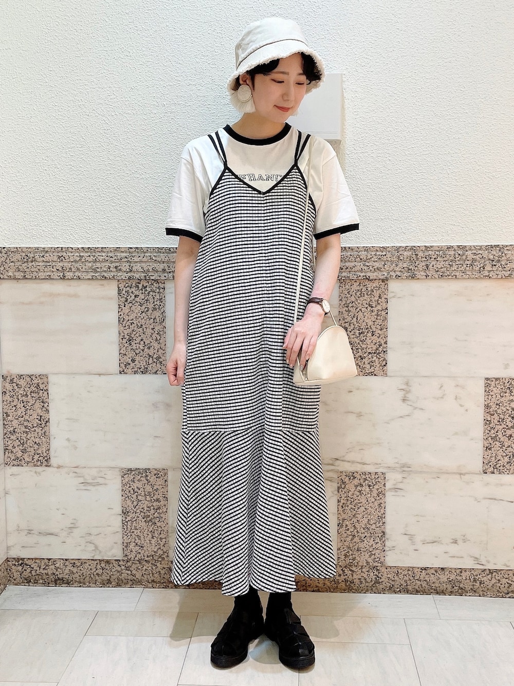 ホワイト系のニット/セーター、ブラック系のワンピース、ホワイト系のショルダーバッグを着用したレディースの春コーディネートの1枚目の写真