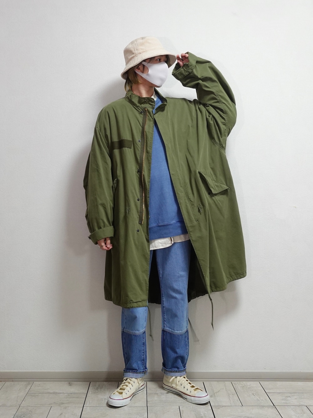 ホワイト系のスニーカー、グリーン系のモッズコート、ブルー系のスウェットを着用したメンズの春コーディネートの1枚目の写真