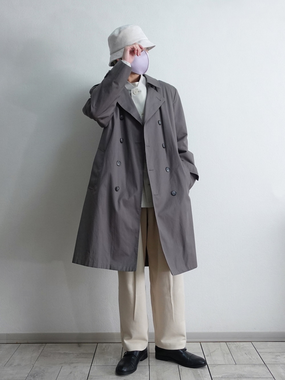 ブラック系のドレスシューズ、ホワイト系のスウェットパンツ、グレー系のトレンチコートを着用したメンズの冬コーディネートの1枚目の写真