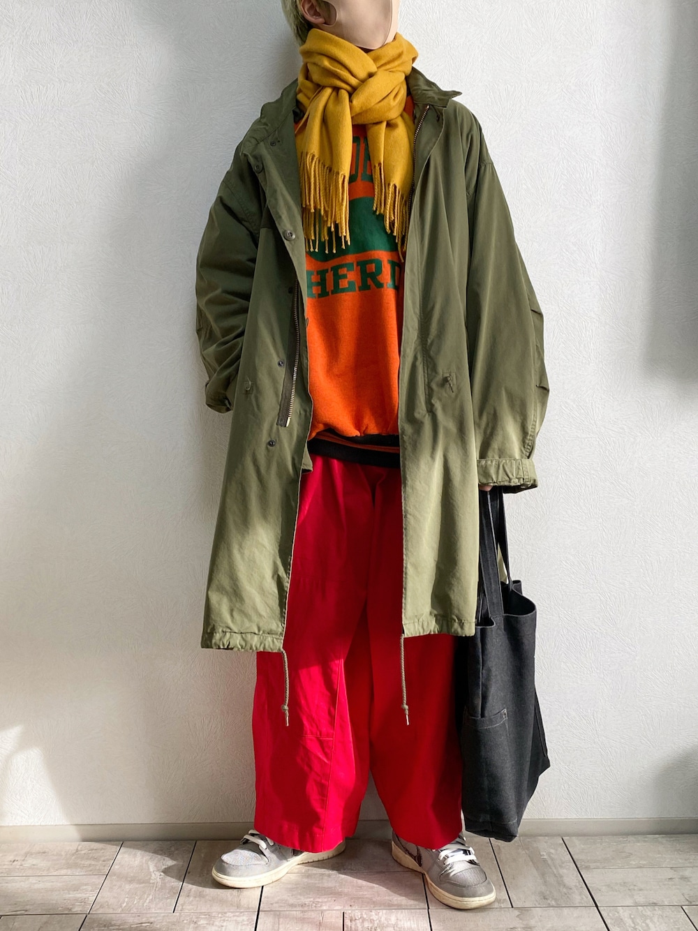 グレー系のスニーカー、ブラック系のトートバッグ、レッド系のカーゴパンツを着用したメンズの冬コーディネートの1枚目の写真