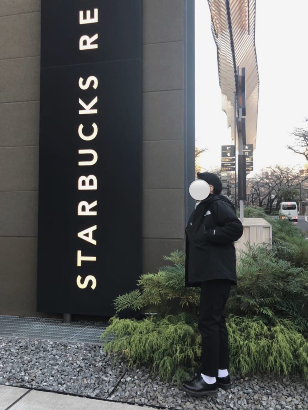 ブラック系のマウンテンパーカー、ブラック系のスラックス、ブラック系のブーツを着用したメンズの冬コーディネートの1枚目の写真