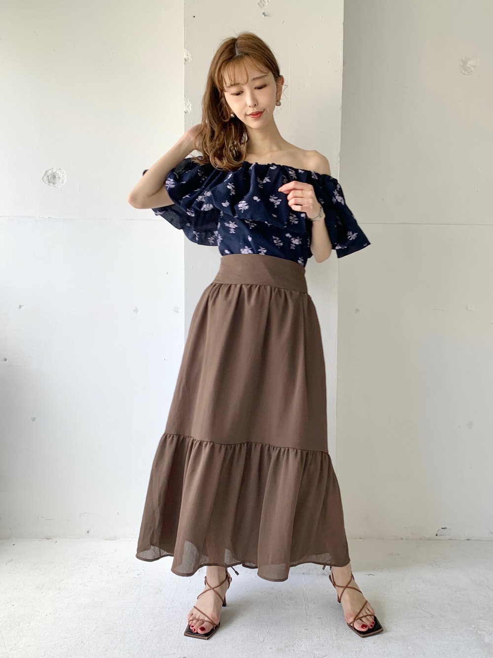 ブラウン系のスカート、ブルー系のシャツ/ブラウス、ブラウン系のサンダルを着用したレディースの春コーディネートの1枚目の写真