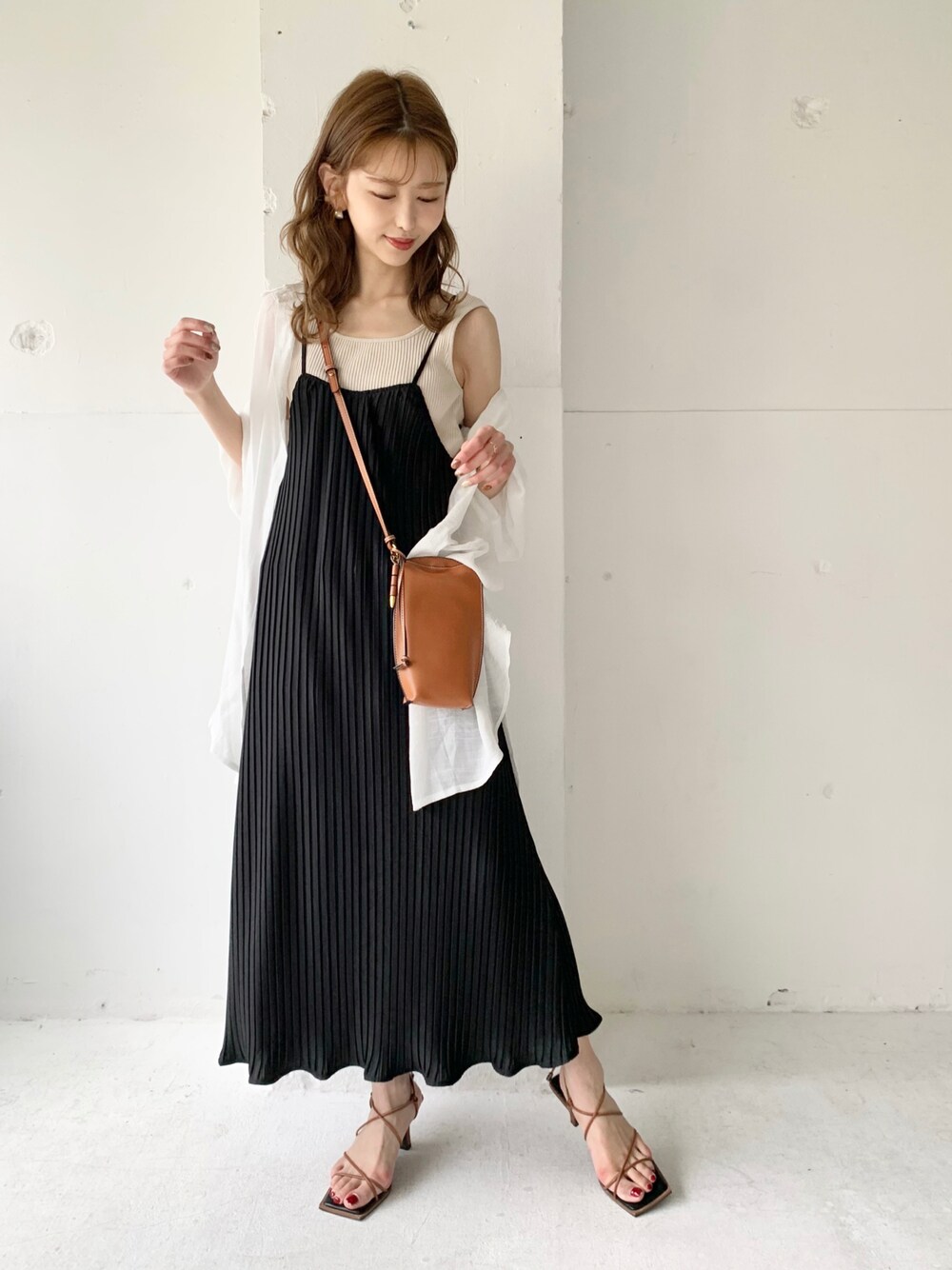 ブラック系のワンピース、ホワイト系のシャツ/ブラウス、ゴールド系のイヤリングを着用したレディースの夏コーディネートの1枚目の写真