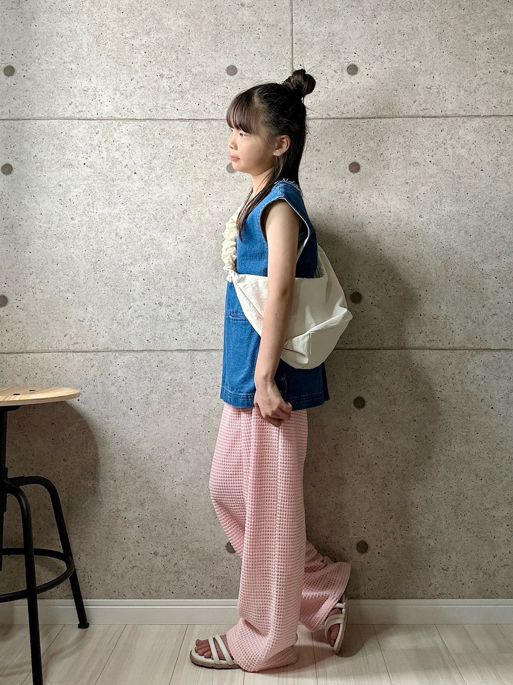 ホワイト系のショルダーバッグ、ピンク系のパンツ、ホワイト系のサンダルを着用したキッズの夏コーディネートの1枚目の写真