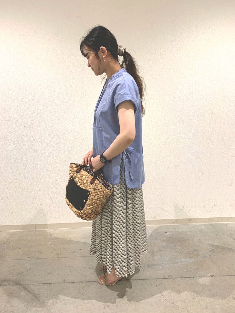 ブルー系のシャツ/ブラウス、ホワイト系のスカート、ブラック系のかごバッグを着用したレディースの夏コーディネートの1枚目の写真