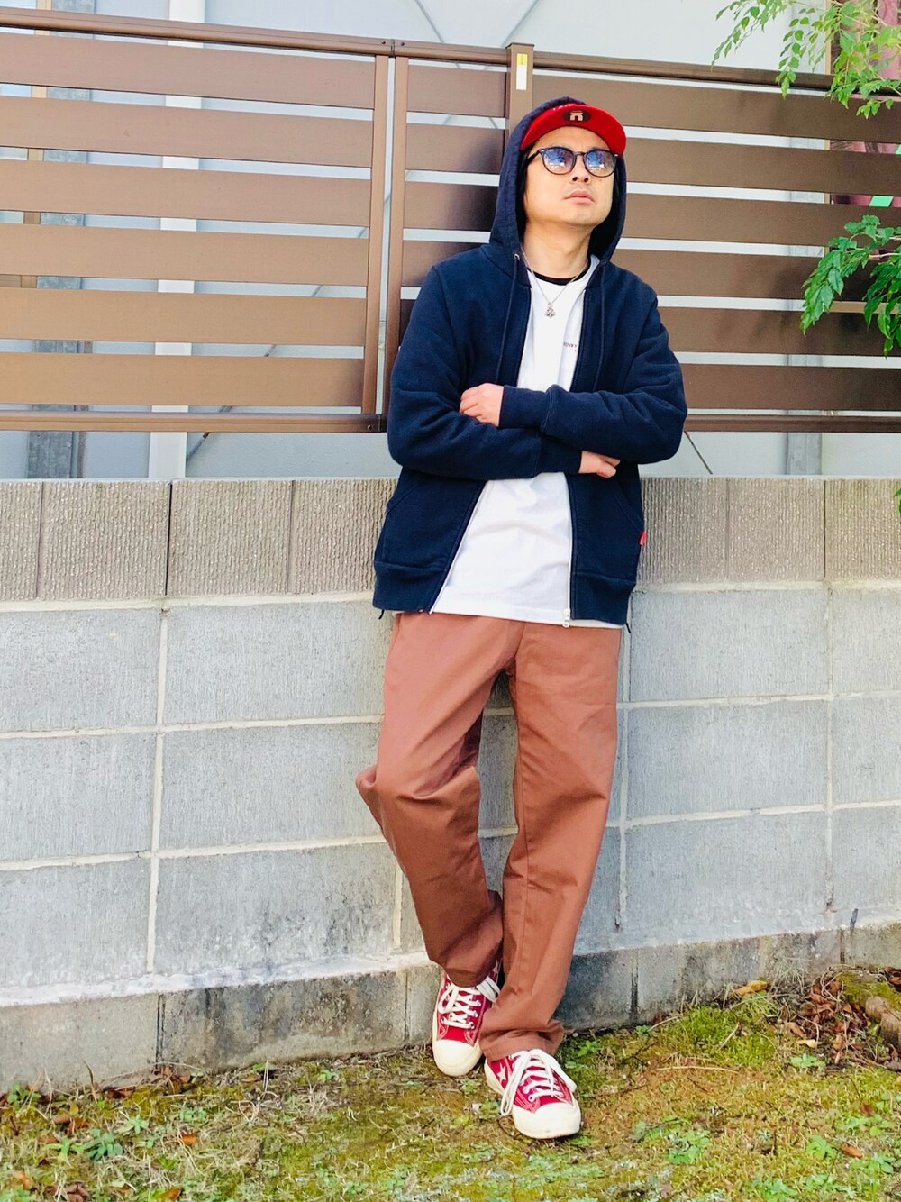ブラック系のパーカー、ホワイト系のTシャツ/カットソー、ブラウン系のパンツを着用したメンズの冬コーディネートの1枚目の写真