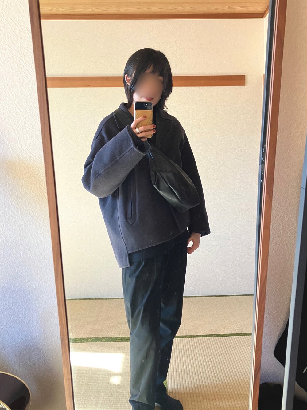 ブラック系のスラックス、グレー系のジャケット/アウター、ブラック系のショルダーバッグを着用したレディースの冬コーディネートの1枚目の写真