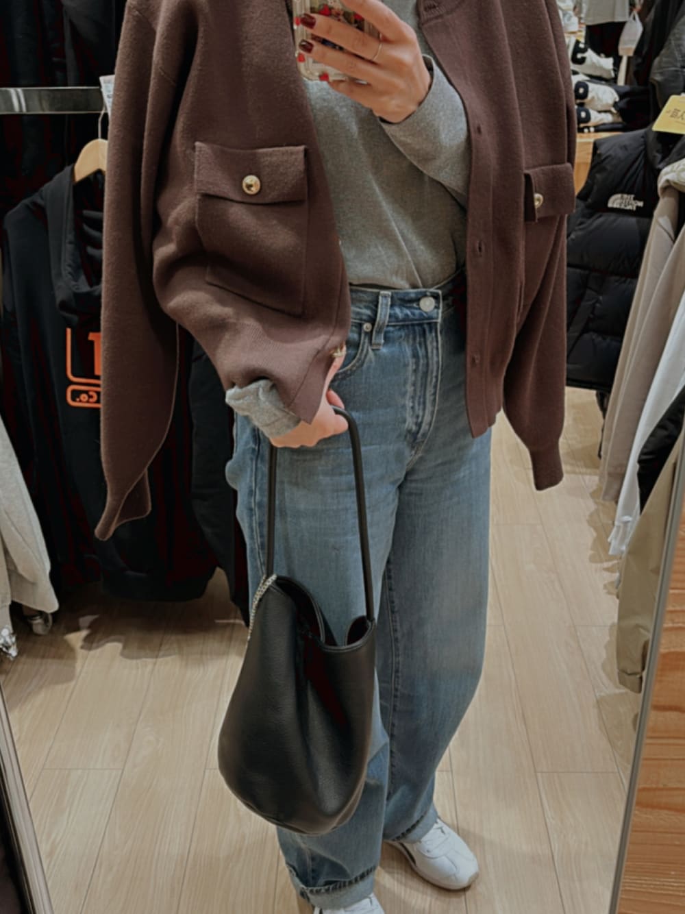 シルバー系のTシャツ/カットソー、ブラウン系のカーディガン/ボレロ、ブルー系のデニムパンツを着用したレディースの秋コーディネートの1枚目の写真