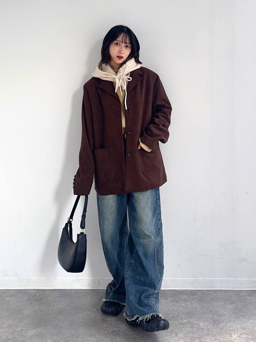 ブラウン系のテーラードジャケット、グリーン系のデニムパンツ、ブラック系のスニーカーを着用したレディースの秋コーディネートの1枚目の写真