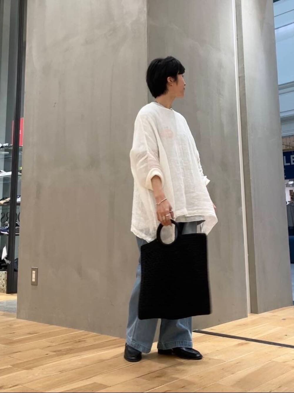 グレー系のTシャツ/カットソー、ブラック系のサンダル、ブルー系のデニムパンツを着用したレディースの夏コーディネートの1枚目の写真