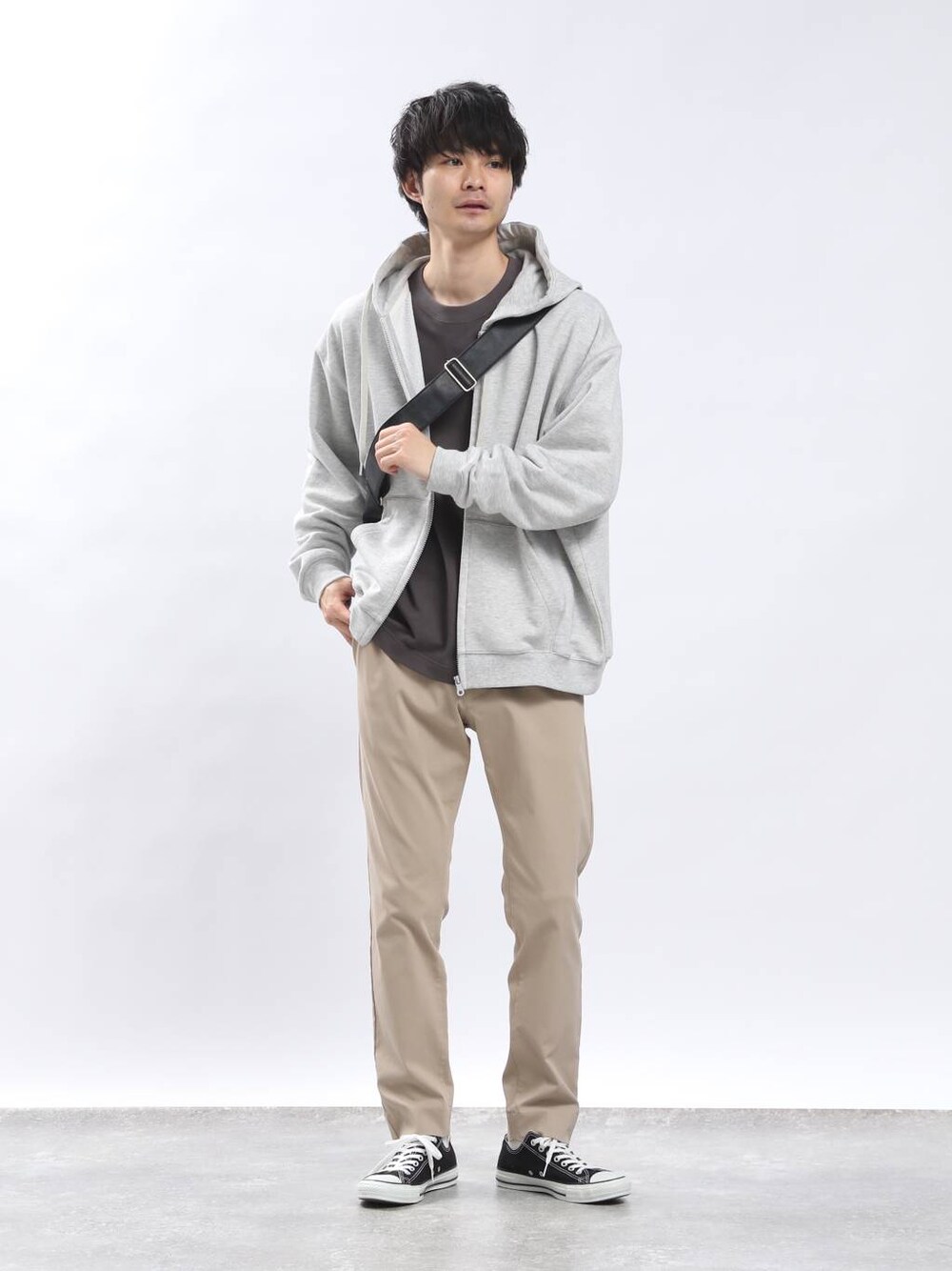 ベージュ系のその他パンツ、グレー系のTシャツ/カットソー、ブラック系のショルダーバッグを着用したメンズの春コーディネートの1枚目の写真