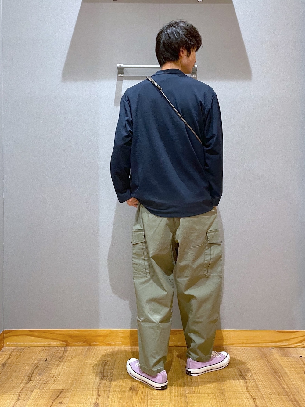 グリーン系のデニムパンツ、グレー系のニット/セーター、ホワイト系のTシャツ/カットソーを着用したメンズの春コーディネートの3枚目の写真