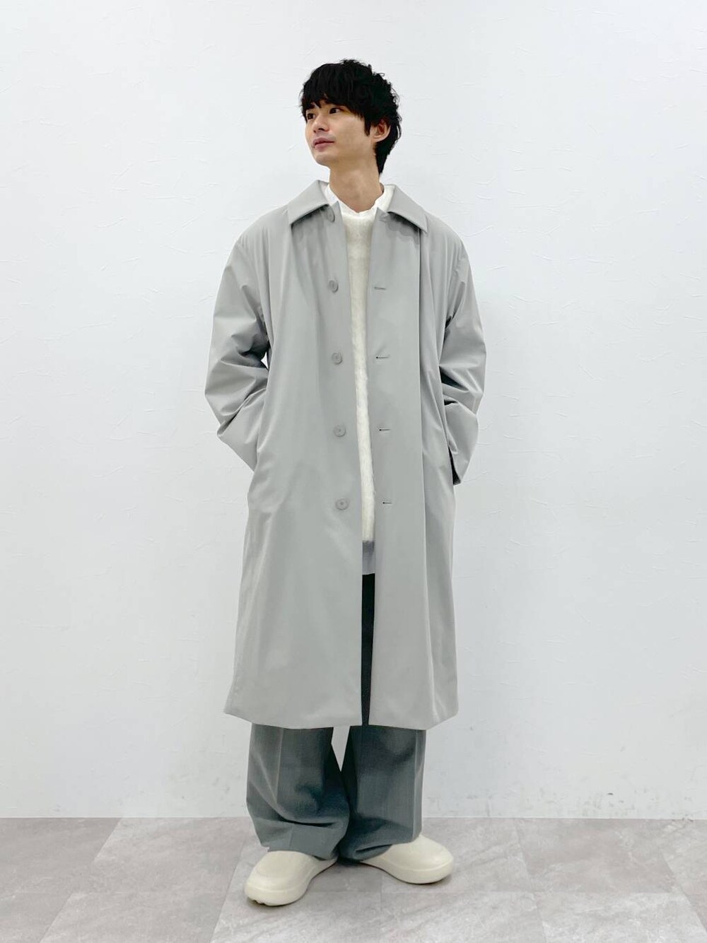 ホワイト系のシャツ/ブラウス、ホワイト系のニット/セーター、グレー系のスラックスを着用したメンズの冬コーディネートの1枚目の写真