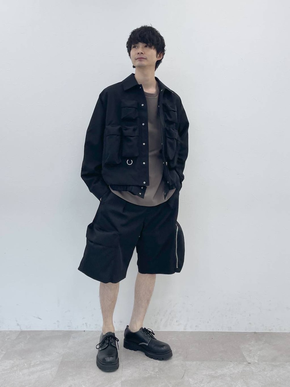 ブラック系のブルゾン、ブラウン系のTシャツ/カットソー、ブラック系のカーゴパンツを着用したメンズの冬コーディネートの1枚目の写真