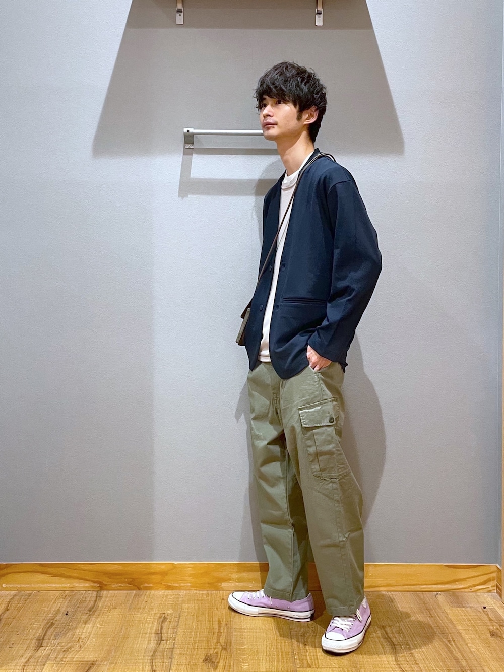 グリーン系のデニムパンツ、グレー系のニット/セーター、ホワイト系のTシャツ/カットソーを着用したメンズの春コーディネートの2枚目の写真