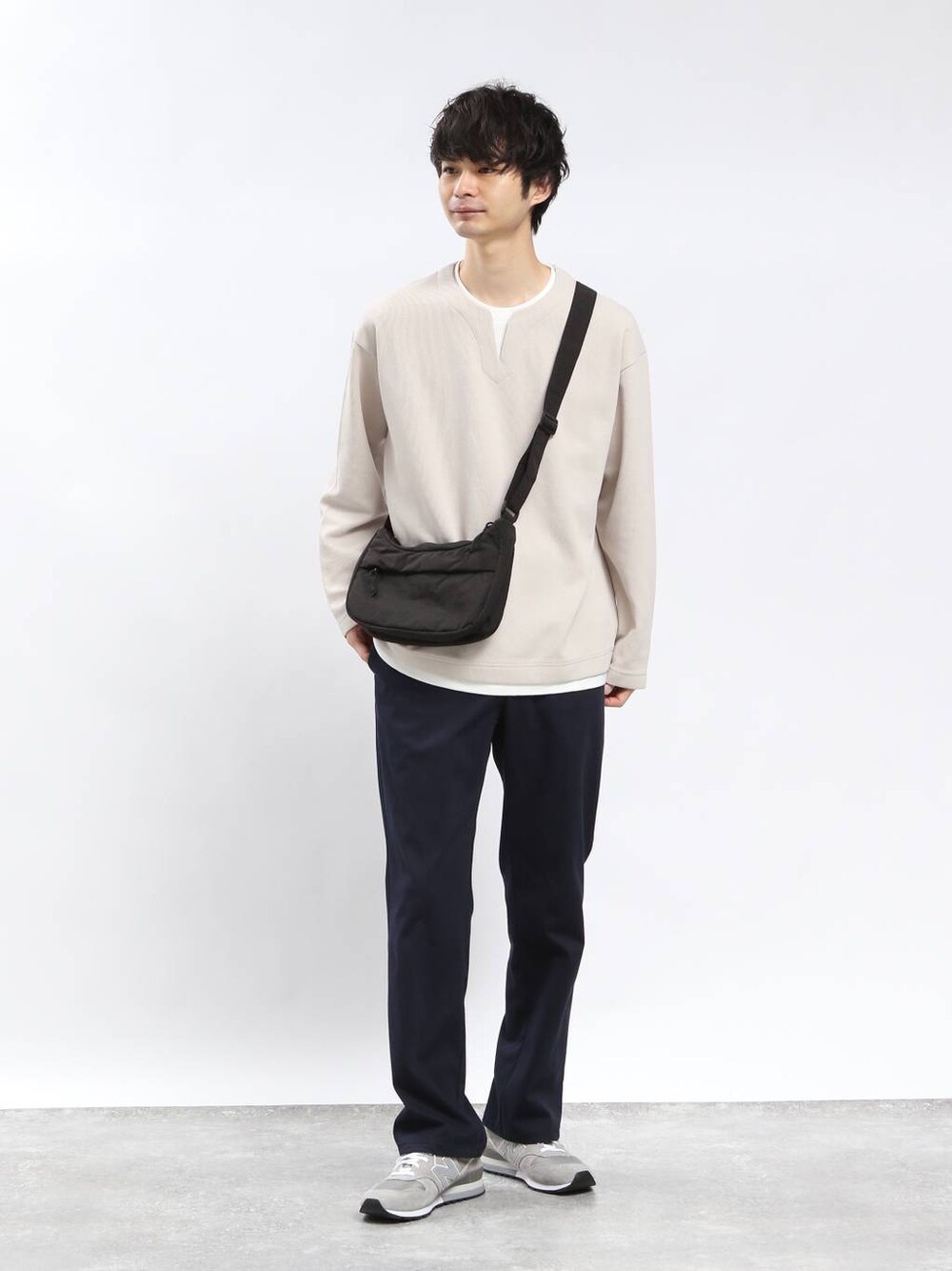 ブルー系のその他パンツ、ブラック系のショルダーバッグ、ベージュ系のTシャツ/カットソーを着用したメンズの春コーディネートの1枚目の写真