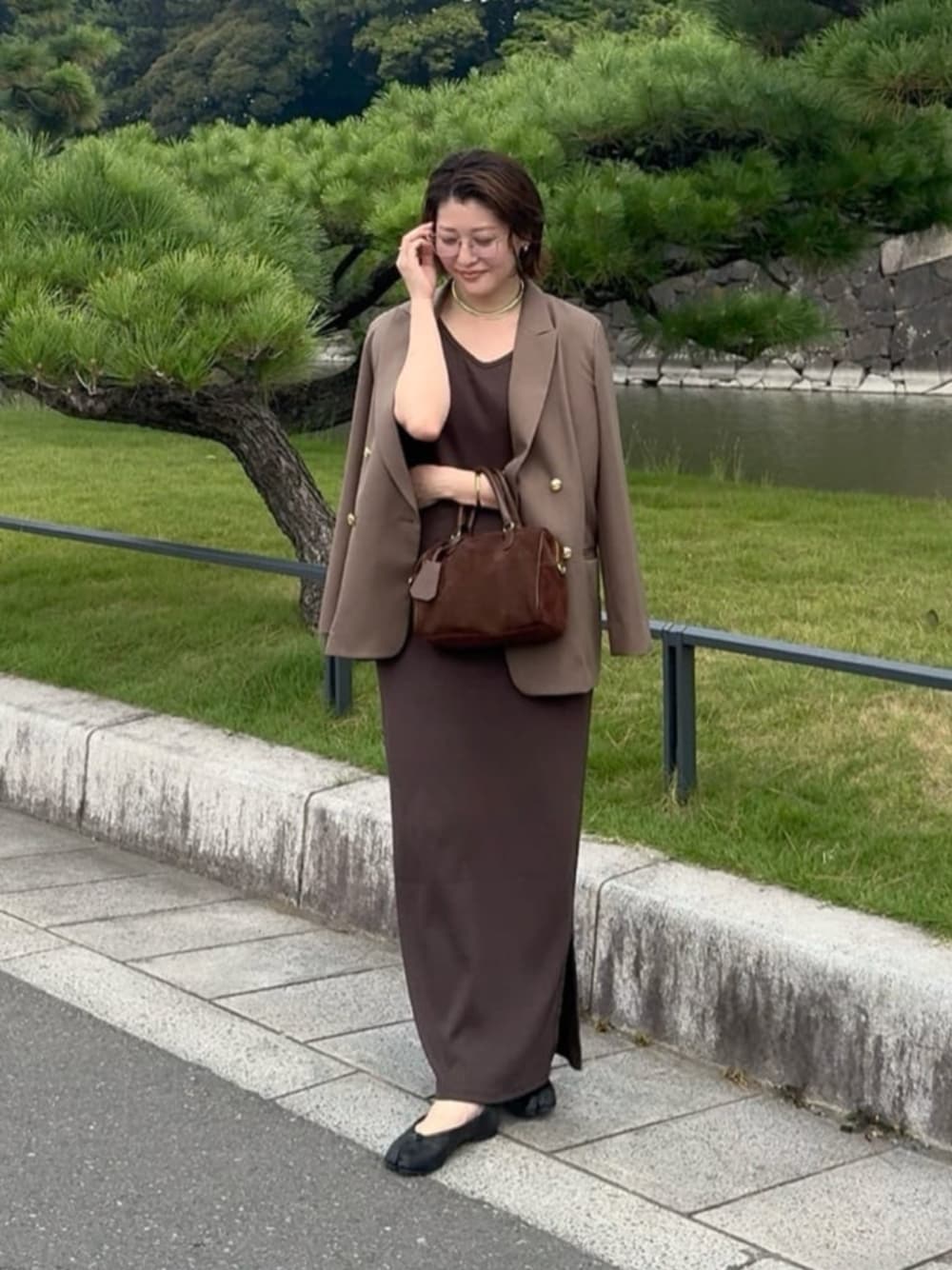 ブラウン系のテーラードジャケット、ブラウン系のワンピース、ゴールド系のチョーカーを着用したレディースの秋コーディネートの1枚目の写真