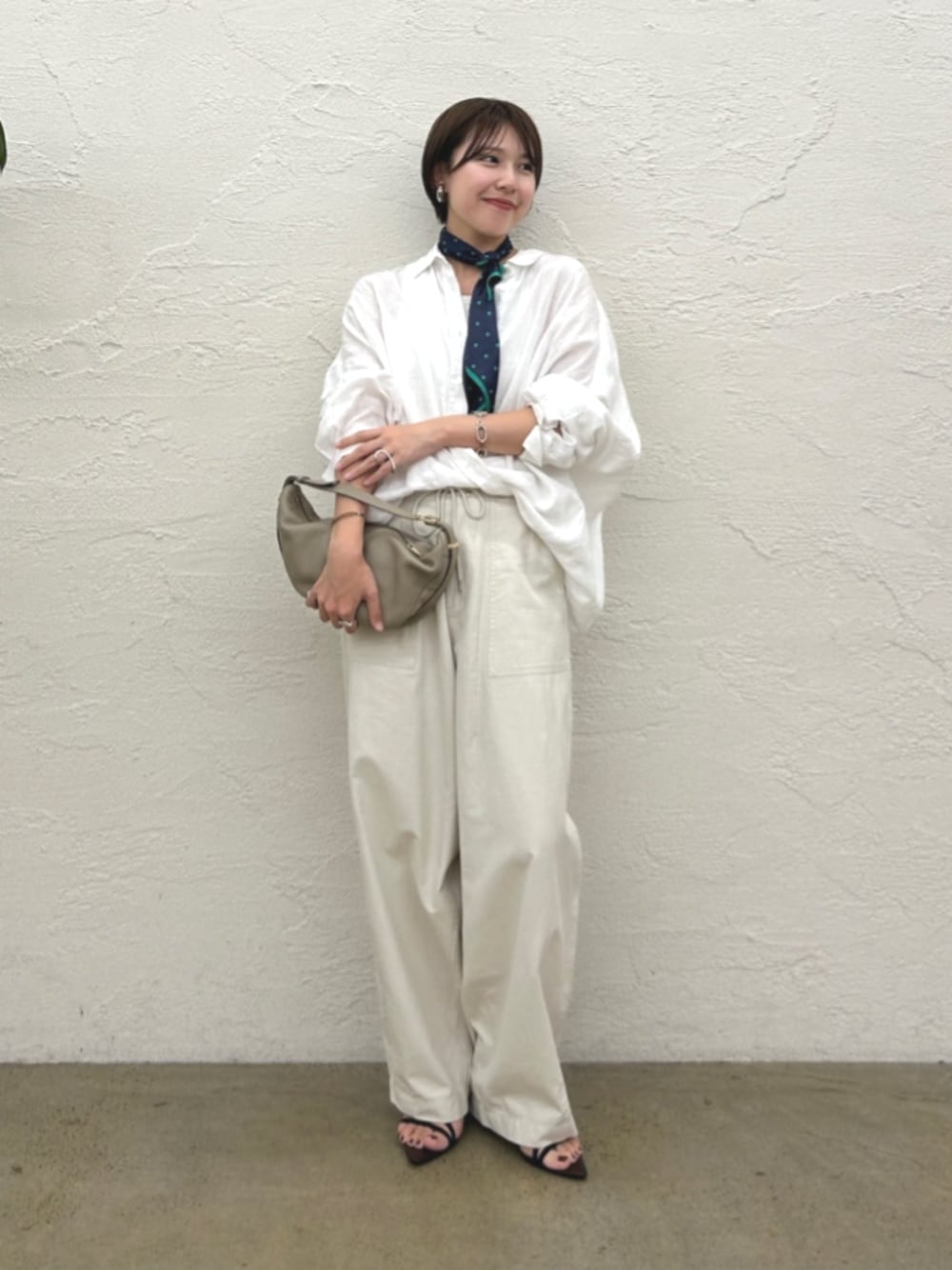 ホワイト系のシャツ/ブラウス、ブラック系のサンダル、ベージュ系のショルダーバッグを着用したレディースの夏コーディネートの1枚目の写真